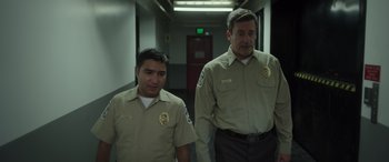Movie still from “Maggie Moore(s)” (2023), directed by John Slattery – A couple of men standing next to each other in a hallway; Medium shot, Low angle