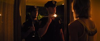 Movie still from “Magic Mike's Last Dance” (2023), directed by Steven Soderbergh – Two police officers are standing next to each other; Medium shot, Low angle