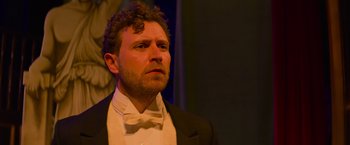 Movie still from “Magic Mike's Last Dance” (2023), directed by Steven Soderbergh – A person wearing a suit and bow tie; Close Up shot, Low angle