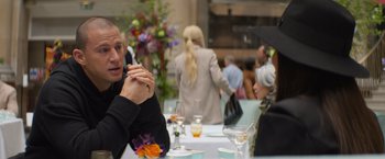 Movie still from “Magic Mike's Last Dance” (2023), directed by Steven Soderbergh – Two people are sitting at a table and talking to each other; Medium shot, Over the shoulder angle