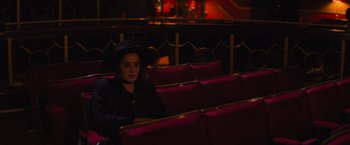 Movie still from “Magic Mike's Last Dance” (2023), directed by Steven Soderbergh – A woman in a hat sitting in a theater; Medium shot, High angle