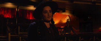 Movie still from “Magic Mike's Last Dance” (2023), directed by Steven Soderbergh – A woman in a black hat is posing for a picture; Close Up shot, Over the shoulder angle