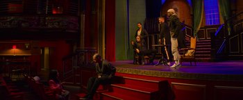 Movie still from “Magic Mike's Last Dance” (2023), directed by Steven Soderbergh – A group of people sitting on top of a set of stairs; Wide shot, High angle