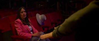 Movie still from “Magic Mike's Last Dance” (2023), directed by Steven Soderbergh – A person wearing a hat sitting in a movie theater; Medium shot, Over the shoulder angle