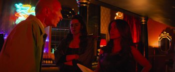 Movie still from “Magic Mike's Last Dance” (2023), directed by Steven Soderbergh – A group of people standing in a room talking to each other; Medium shot, Over the shoulder angle