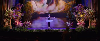 Movie still from “Magic Mike's Last Dance” (2023), directed by Steven Soderbergh – A woman in a white tutu is on stage; Extreme Wide shot, Low angle