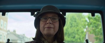 Movie still from “Magic Mike's Last Dance” (2023), directed by Steven Soderbergh – A person wearing glasses and a hat; Close Up shot, Low angle