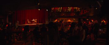 Movie still from “Magic Mike's Last Dance” (2023), directed by Steven Soderbergh – People are sitting at tables in front of a stage; Extreme Wide shot, High angle