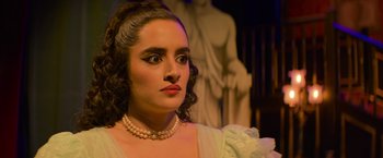 Movie still from “Magic Mike's Last Dance” (2023), directed by Steven Soderbergh – A person wearing a dress and pearls; Close Up shot, Over the shoulder angle