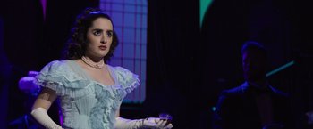 Movie still from “Magic Mike's Last Dance” (2023), directed by Steven Soderbergh – A woman in a blue dress holding a glass of wine; Medium shot, Over the shoulder angle