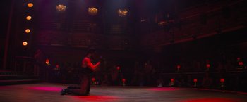 Movie still from “Magic Mike's Last Dance” (2023), directed by Steven Soderbergh – A man kneeling on the ground in front of an audience; Extreme Wide shot, High angle