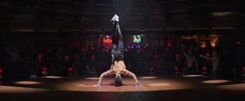 Movie still from “Magic Mike's Last Dance” (2023), directed by Steven Soderbergh – A man doing a handstand on a dance floor; Wide shot, Low angle