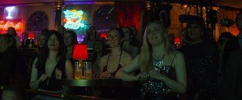 Movie still from “Magic Mike's Last Dance” (2023), directed by Steven Soderbergh – A group of women sitting at a bar watching a show; Medium shot, Low angle