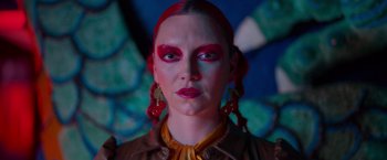 Movie still from “Making It Up” (2023), directed by Guillermo Calderón – A person with red hair and red lipstick; Close Up shot, Low angle
