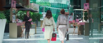 Movie still from “Making It Up” (2023), directed by Guillermo Calderón – Two women walking down the street holding shopping bags; Wide shot, Over the shoulder angle