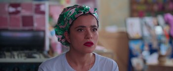 Movie still from “Making It Up” (2023), directed by Guillermo Calderón – A person wearing a head wrap; Close Up shot, Over the shoulder angle