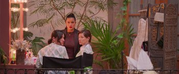 Movie still from “Making It Up” (2023), directed by Guillermo Calderón – A group of women standing next to each other in front of a tree; Medium shot, Over the shoulder angle