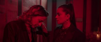 Movie still from “Making It Up” (2023), directed by Guillermo Calderón – Two women in a red room looking at each other; Close Up shot, Over the shoulder angle