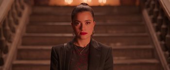 Movie still from “Making It Up” (2023), directed by Guillermo Calderón – A woman in a black jacket and a red shirt; Close Up shot, Over the shoulder angle