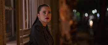 Movie still from “Making It Up” (2023), directed by Guillermo Calderón – A woman with red lipstick is standing by a window; Close Up shot, Over the shoulder angle