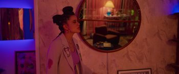 Movie still from “Making It Up” (2023), directed by Guillermo Calderón – A woman standing in front of a round mirror; Medium shot, Over the shoulder angle