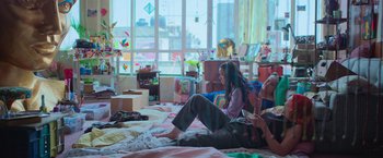 Movie still from “Making It Up” (2023), directed by Guillermo Calderón – Two young people sitting on the floor of a room; Wide shot, High angle