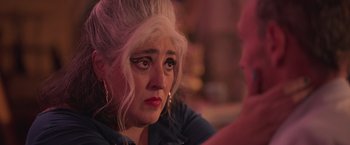 Movie still from “Making It Up” (2023), directed by Guillermo Calderón – An older woman is looking down at the floor; Close Up shot, Over the shoulder angle