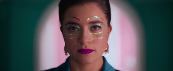 Movie still from “Making It Up” (2023), directed by Guillermo Calderón – A person with makeup on their face; Close Up shot, Low angle