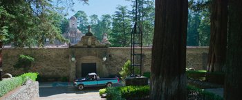 Movie still from “Making It Up” (2023), directed by Guillermo Calderón – A truck parked in front of an old building; Extreme Wide shot, High angle
