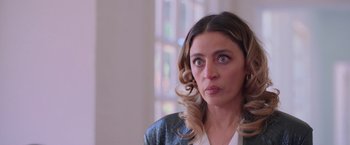 Movie still from “Making It Up” (2023), directed by Guillermo Calderón – A person wearing a leather jacket; Close Up shot, Over the shoulder angle