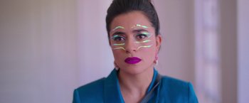 Movie still from “Making It Up” (2023), directed by Guillermo Calderón – A young woman with bright makeup on her face; Close Up shot, Over the shoulder angle