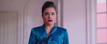 Movie still from “Making It Up” (2023), directed by Guillermo Calderón – A woman in a blue jacket with white lines on her face; Close Up shot, Over the shoulder angle