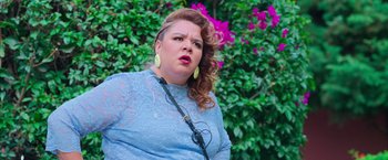 Movie still from “Making It Up” (2023), directed by Guillermo Calderón – A woman in a blue shirt and yellow earrings; Close Up shot, Over the shoulder angle