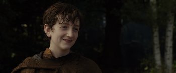 Movie still from “Maleficent” (2014), directed by Robert Stromberg – A young boy with brown hair smiling for the camera; Close Up shot, Low angle