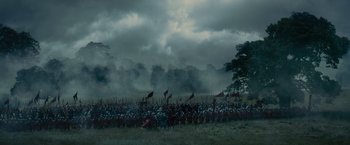 Movie still from “Maleficent” (2014), directed by Robert Stromberg – A crowd of people are gathered in a field under a cloudy sky; Extreme Wide shot, High angle