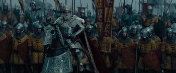Movie still from “Maleficent” (2014), directed by Robert Stromberg – A man in armor in front of a crowd; Wide shot, Low angle