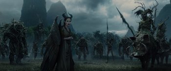 Movie still from “Maleficent” (2014), directed by Robert Stromberg – A group of people that are standing in the grass; Wide shot, Low angle