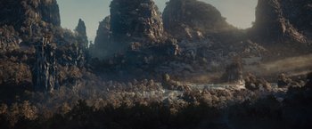 Movie still from “Maleficent” (2014), directed by Robert Stromberg – A view of a mountain range with trees in the foreground; Extreme Wide shot, High angle