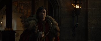 Movie still from “Maleficent” (2014), directed by Robert Stromberg – A man in a fur coat and a red robe; Medium shot, Over the shoulder angle