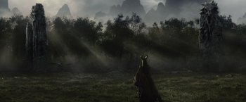 Movie still from “Maleficent” (2014), directed by Robert Stromberg – A person in a field with mountains in the background; Extreme Wide shot, Over the shoulder angle