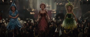 Movie still from “Maleficent” (2014), directed by Robert Stromberg – A girl in a dress is standing in front of a crowd; Wide shot, Low angle