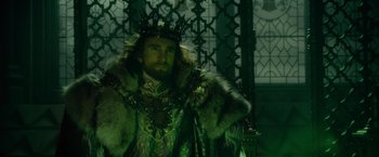 Movie still from “Maleficent” (2014), directed by Robert Stromberg – A man dressed as a king in a green outfit; Medium shot, Low angle