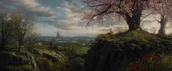 Movie still from “Maleficent” (2014), directed by Robert Stromberg – A view of a castle from a hill with trees in the foreground; Extreme Wide shot, High angle