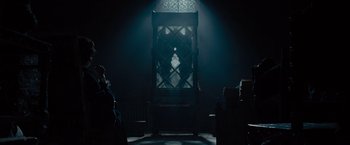 Movie still from “Maleficent” (2014), directed by Robert Stromberg – A large chair in a dark room lit up by a light; Wide shot, Low angle