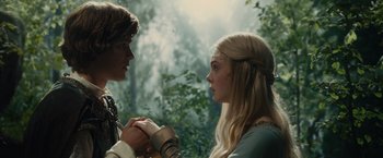 Movie still from “Maleficent” (2014), directed by Robert Stromberg – A man and a woman holding hands in front of a forest; Close Up shot, Low angle