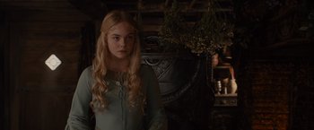 Movie still from “Maleficent” (2014), directed by Robert Stromberg – A woman in a green dress standing in a room; Medium shot, Over the shoulder angle