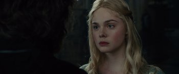 Movie still from “Maleficent” (2014), directed by Robert Stromberg – A young woman with long blonde hair stares into the camera; Close Up shot, Over the shoulder angle