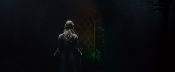 Movie still from “Maleficent” (2014), directed by Robert Stromberg – A woman standing in front of a wall with green lights; Medium shot, Over the shoulder angle