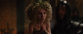 Movie still from “Maleficent” (2014), directed by Robert Stromberg – A young woman with curly blonde hair wearing a green hat; Close Up shot, Over the shoulder angle