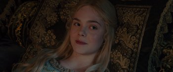 Movie still from “Maleficent” (2014), directed by Robert Stromberg – A young girl with long blonde hair wearing a white dress; Close Up shot, High angle